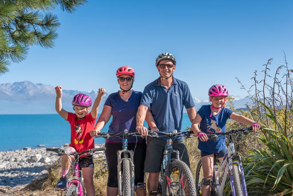 Family beside Lake Pukaki on Alps 2 Ocean Cycle Trail